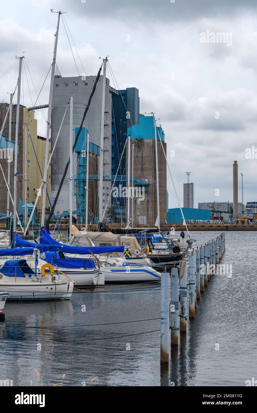 Pequeños veleros en el puerto de Halmstad con edificios industriales en el fondo, enfoque selectivo Foto de stock