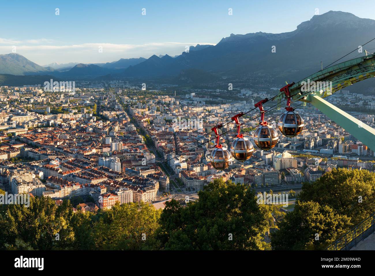 Horizonte de la ciudad de Grenoble al atardecer con teleféricos del Fuerte de la Bastilla. Verano en Isere, región de Ródano-Alpes, Francia Foto de stock