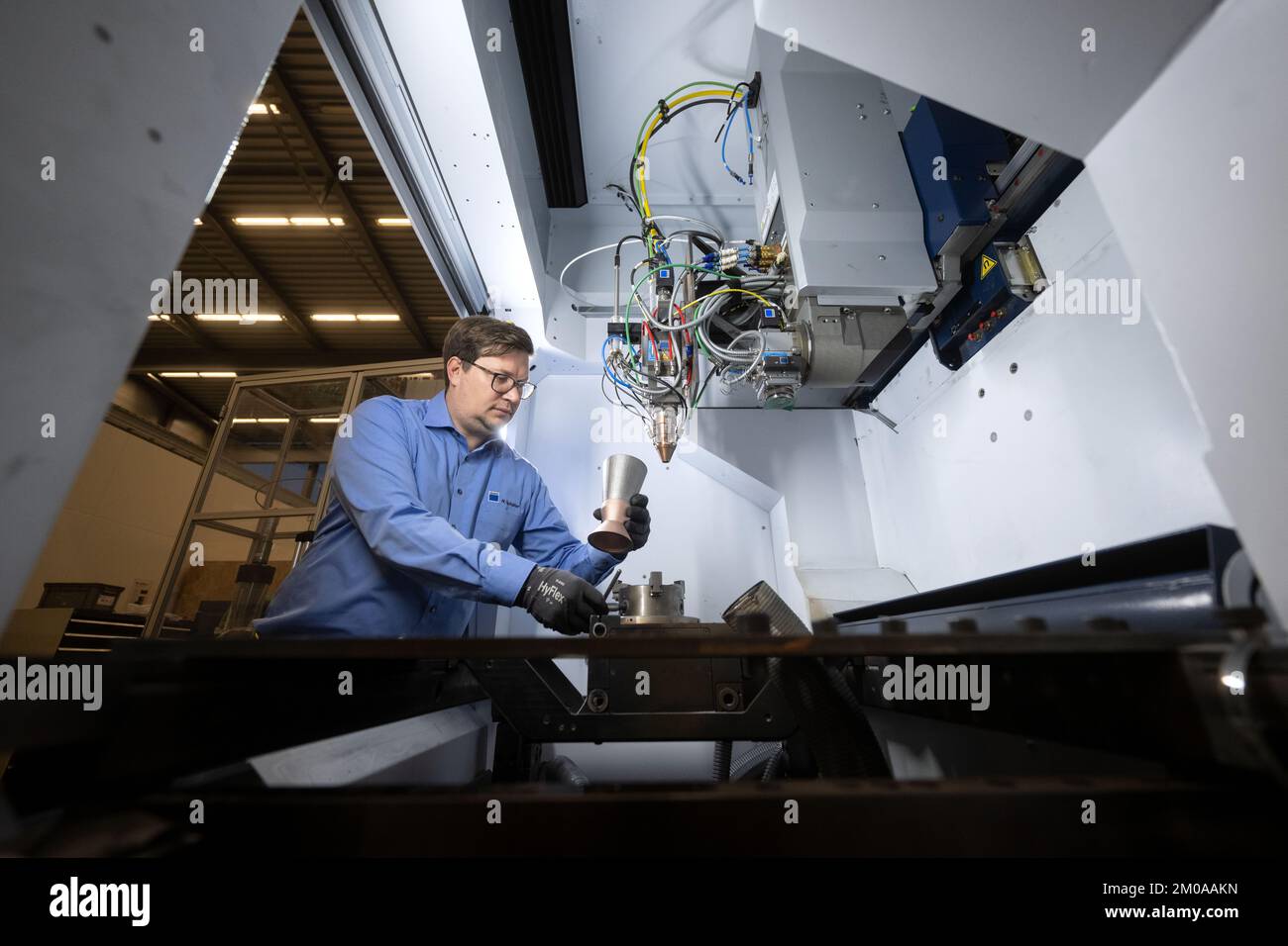Ditzingen, Alemania. 30th de Nov de 2022. Un empleado del especialista en  láser Trumpf utiliza un modelo de propulsor para lanzaderas espaciales para  demostrar la sujeción de una pieza de trabajo en
