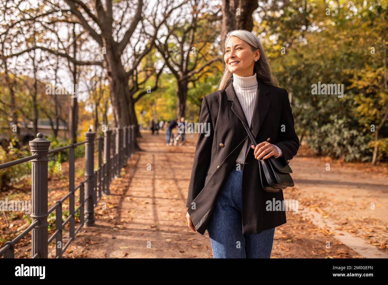Mujer bonita de pelo largo caminando por el parque Foto de stock