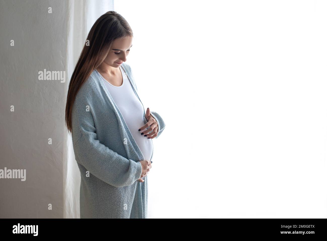 Mujer en el tercer trimestre del embarazo en casa Foto de stock