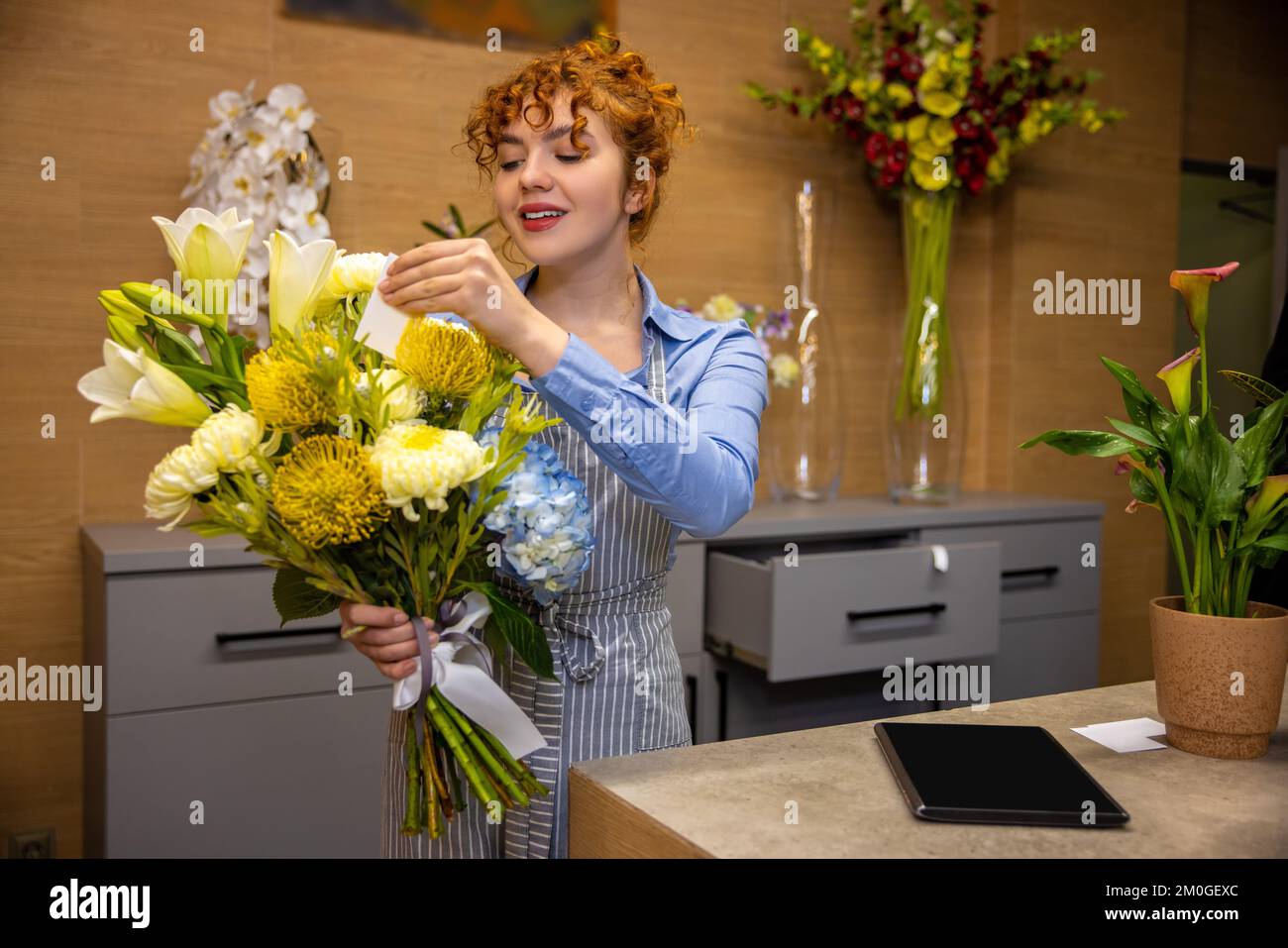 Primer plano de un asistente de tienda con un ramo en las manos Foto de stock