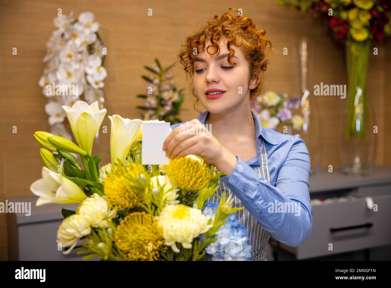 Primer plano de un asistente de tienda con un ramo en las manos Foto de stock