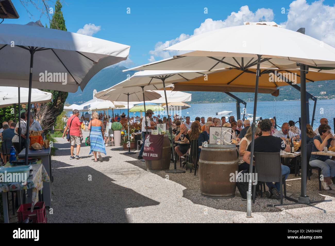 Lagos de Italia, vista de la gente cenando en terrazas de restaurantes al aire libre junto al lago en el pueblo pesquero de Isola Bella, Islas Borromeo, Piamonte, Italia Foto de stock