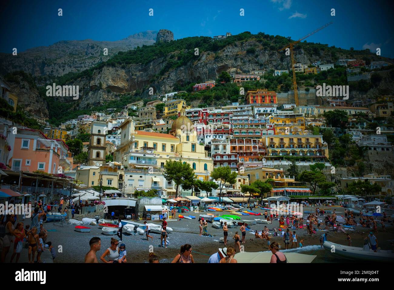 Las coloridas casas, tiendas y hoteles de Positano se superponían verticalmente en los acantilados con vistas a la playa Marina grande de Italia. Foto de stock