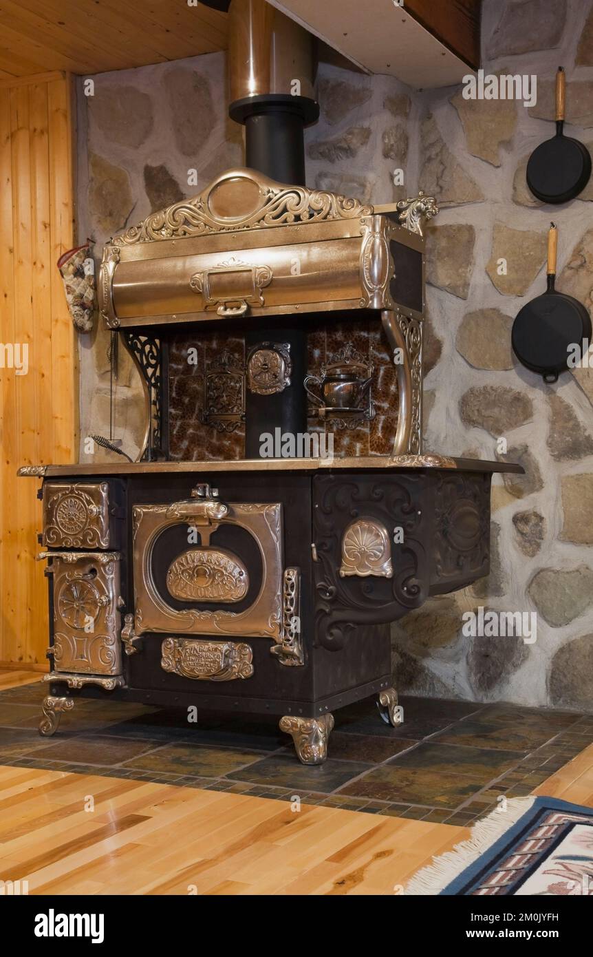 Antigua cocina de hierro fundido de madera en la habitación familiar del sótano dentro de 1978 réplica construida de la antigua casa de madera y piedra de campo estilo cabaña Canadiana. Foto de stock