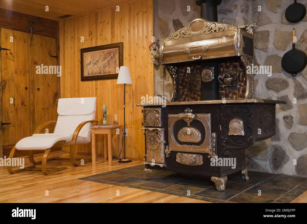 Antigua cocina de hierro fundido de madera en la habitación familiar del sótano dentro de 1978 réplica construida de la antigua casa de madera y piedra de campo estilo cabaña Canadiana. Foto de stock