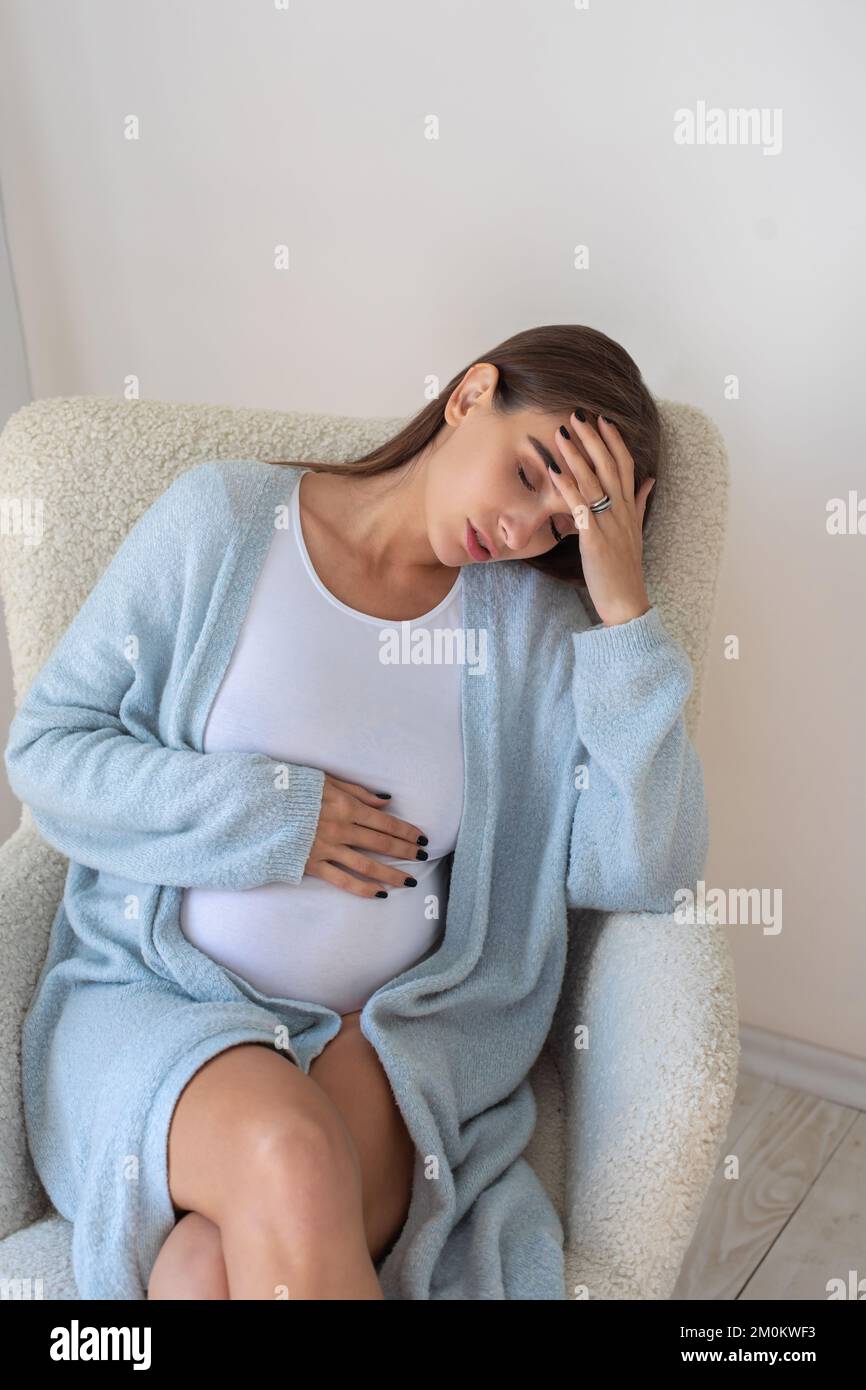 Mujer embarazada joven que tiene dolor de cabeza Foto de stock