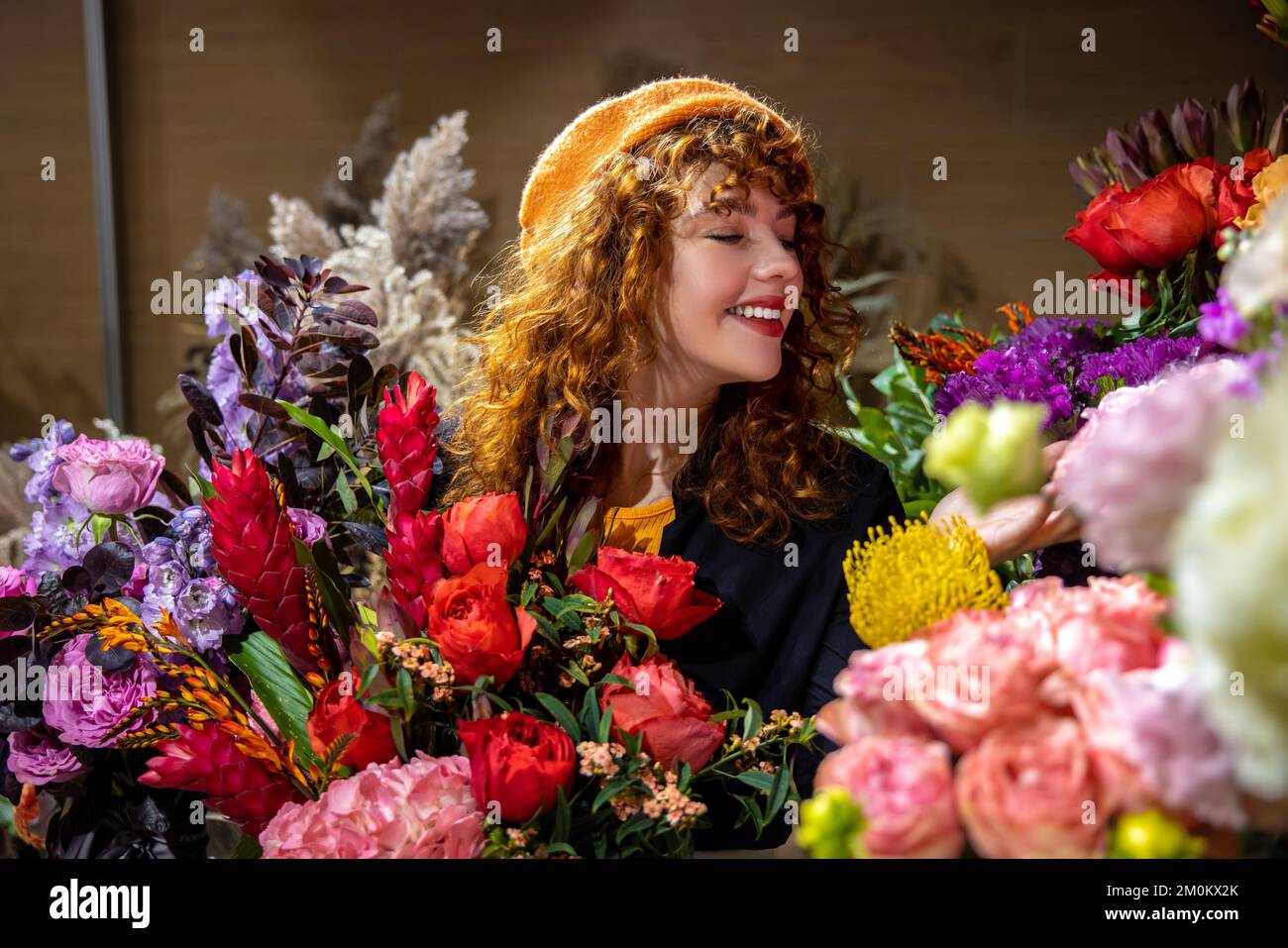Sonriendo mujer joven bonita en una floristería Foto de stock
