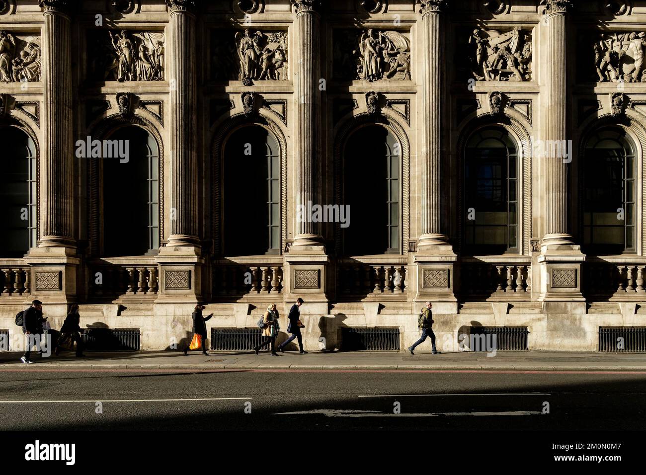 Los peatones pasan por la arquitectura clásica del Gibson Hall en Bishopsgate en la ciudad de Londres, Reino Unido. Foto de stock