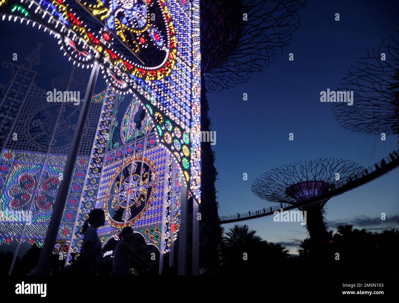 La gente pasa las decoraciones de Navidad entre los Superárboles en los Jardines junto a la Bahía en Singapur 7 de diciembre de 2022. REUTERS/Edgar Su Foto de stock