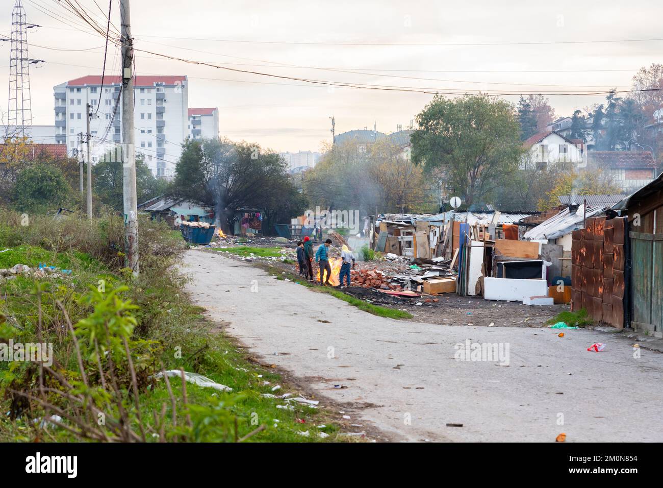 Belgrado, Serbia - 17 de noviembre de 2022: Un grupo de niños gipsy arrasaron el incendio en una zona pobre. La población romaní vive en la pobreza cerca del vertedero lleno de plantas agrícolas Foto de stock