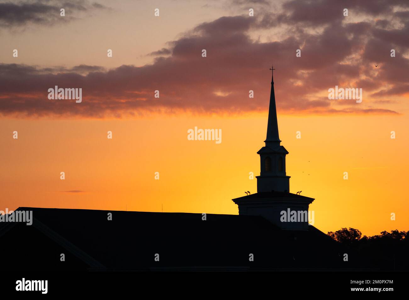 Una silueta de una antigua iglesia durante la puesta del sol Foto de stock