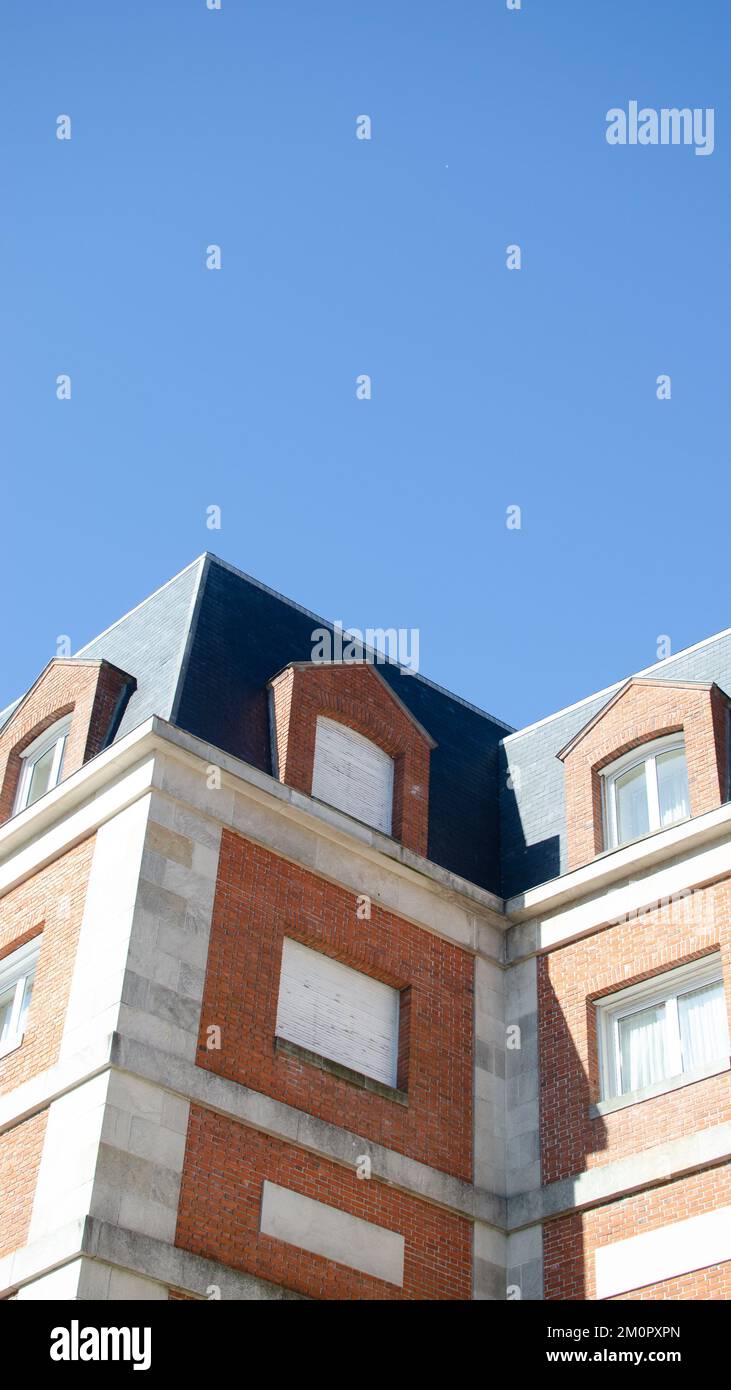Una fotografía en ángulo bajo de un colorido edificio con patrones geométricos bajo un cielo azul claro Foto de stock