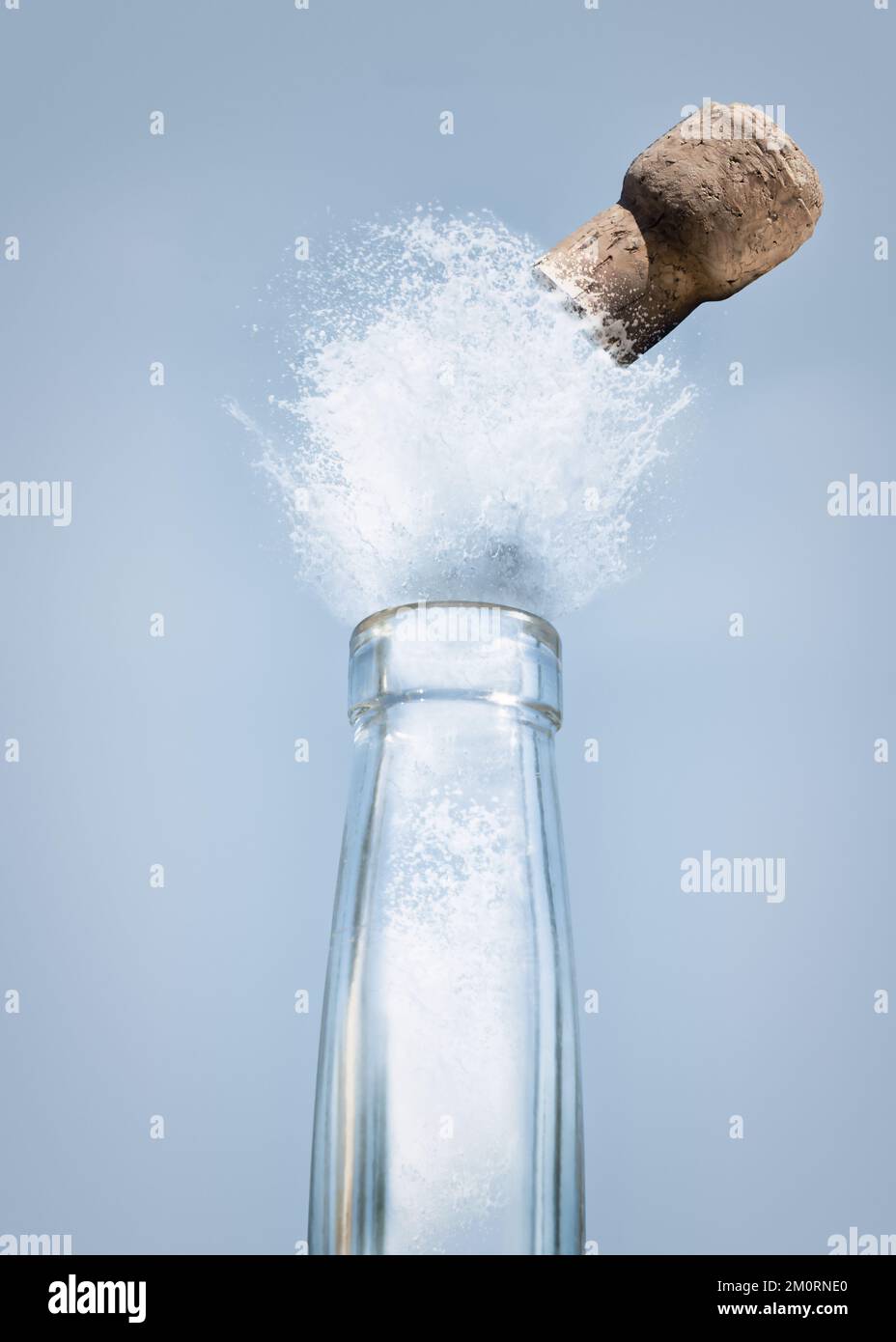 Primer plano de líquido y un corcho explotando fuera de una botella larga del cuello Foto de stock