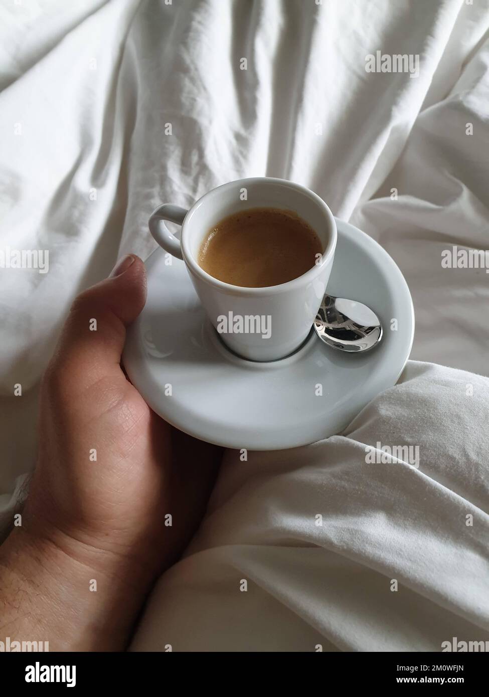 Tomando café expreso en la cama en un hotel Fotografía de stock - Alamy