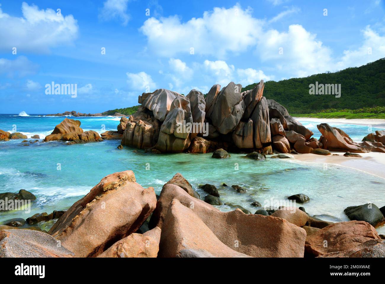 Anse Cocos playa con grandes piedras de granito en la isla de la Digue, Océano Índico, Seychelles. Paisaje tropical con cielo soleado. Destino exótico del viaje. Foto de stock