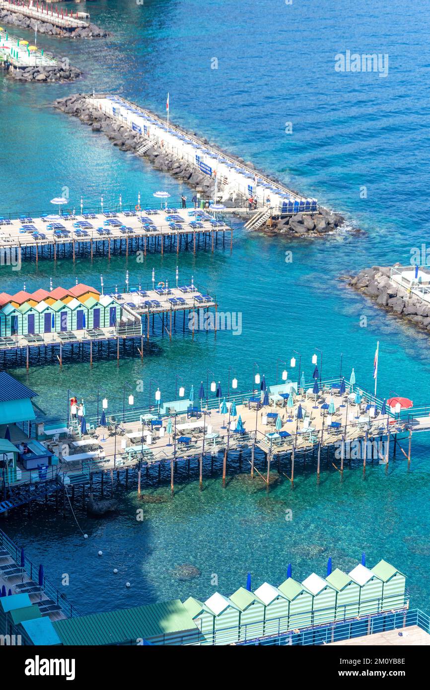 Vista de los malecones del club de playa desde la terraza Villa Comunale (jardín público), Sorrento (Surriento), región Campania, Italia Foto de stock