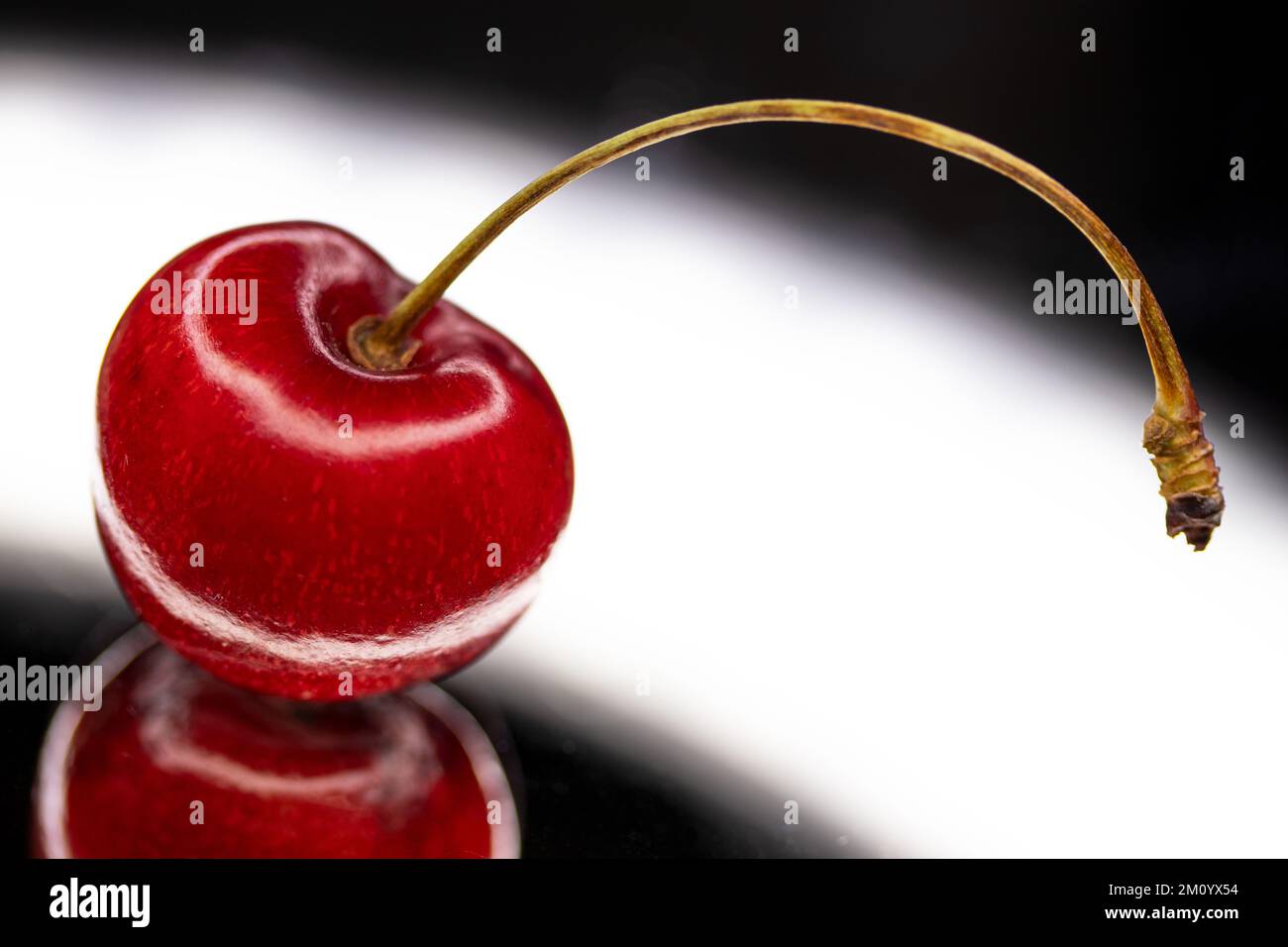 cereza en plano reflectante, fotografía de naturalezas muertas Foto de stock