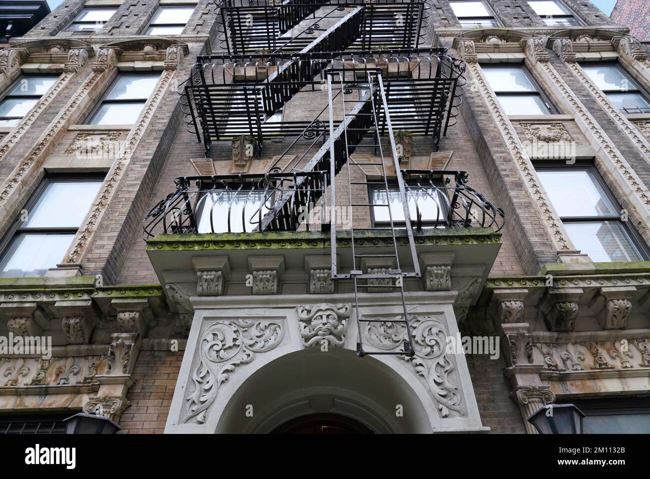 Antigua fachada de edificios de apartamentos con decoraciones barrocas y escape de incendios exterior, en el sur de Manhattan cerca de Greenwich Village Foto de stock