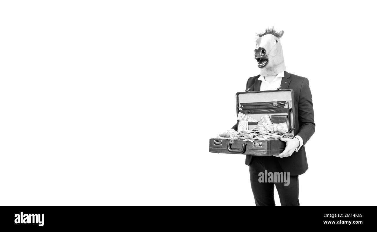 Hombre profesional hombre hombre de negocios usar la máscara de cabeza de caballo que sostiene la maleta con billetes en dólares, dinero. Foto de stock