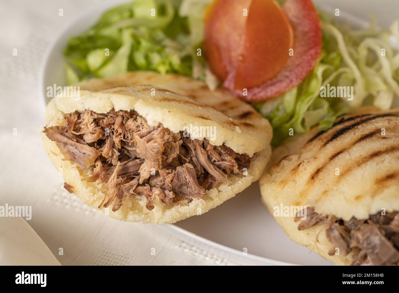 Primer plano de Arepas, comida típica venezolana, elaborada con maíz y rellena de carne desmenuzada. Foto de stock