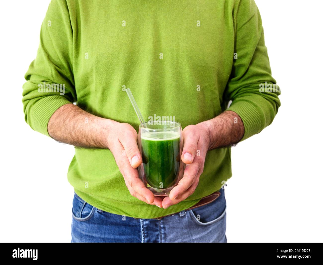 hombre sosteniendo un batido de spirulina sobre un fondo blanco Foto de stock