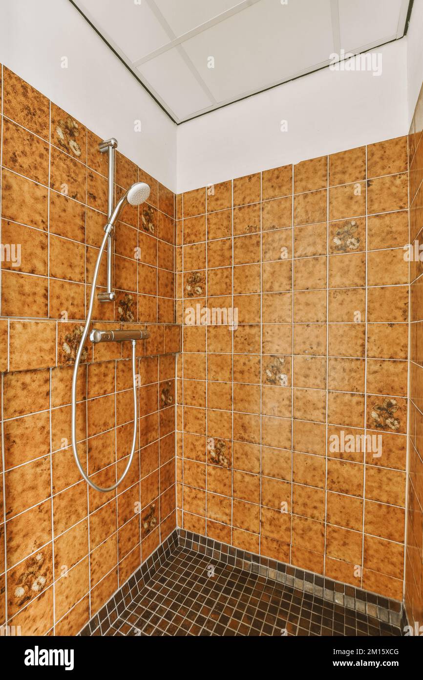 Grifos de ducha unidos a la pared de azulejos cerca de la partición de  vidrio y lavadora en el cuarto de baño en la casa Fotografía de stock -  Alamy