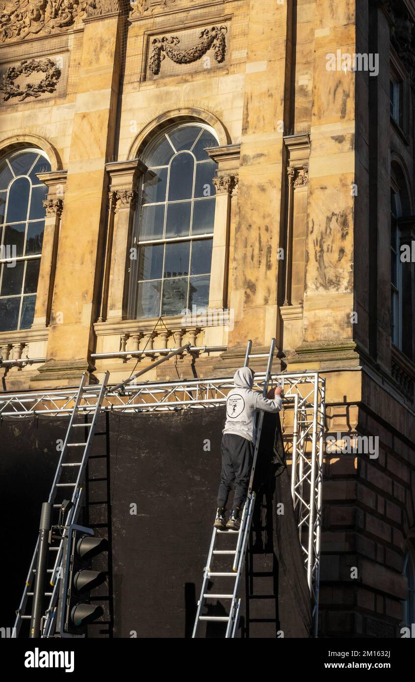 Hombre en la escalera poniendo una persiana sobre una ventana del  Ayuntamiento de Liverpool debido a la filmación en el interior Fotografía  de stock - Alamy