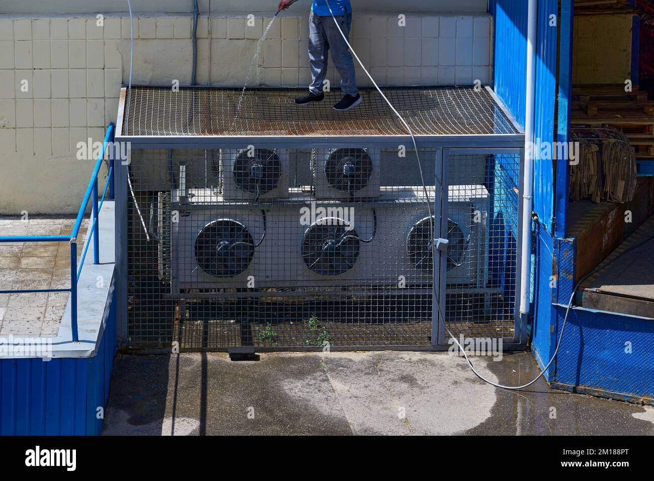 Un trabajador limpia el sistema de aire acondicionado en el patio trasero  de una fábrica Fotografía de stock - Alamy