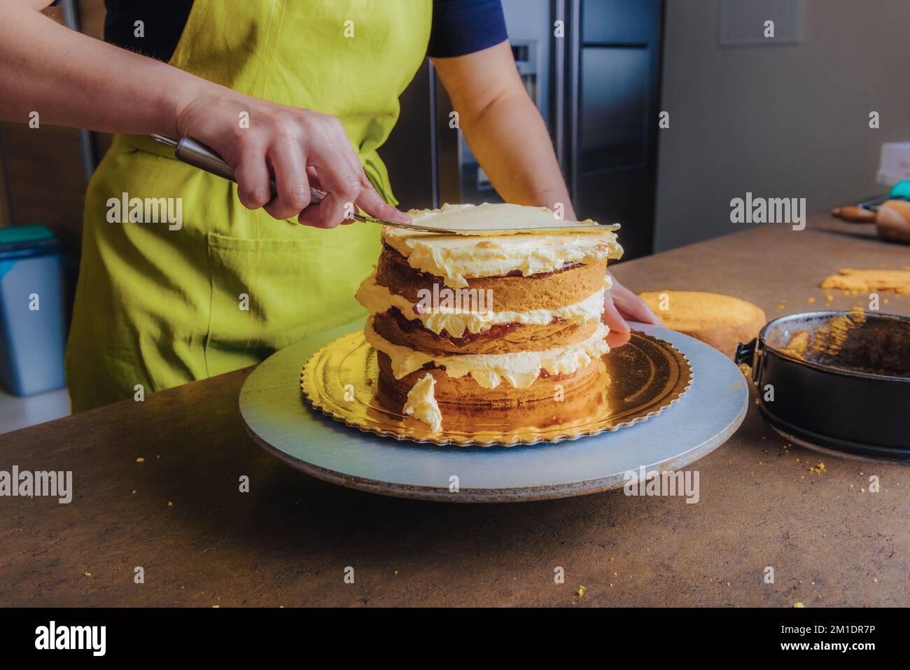 Mujer adornando un delicioso pastel con crema de glaseado. DIY, secuencia, paso a paso, parte de la serie. Foto de stock