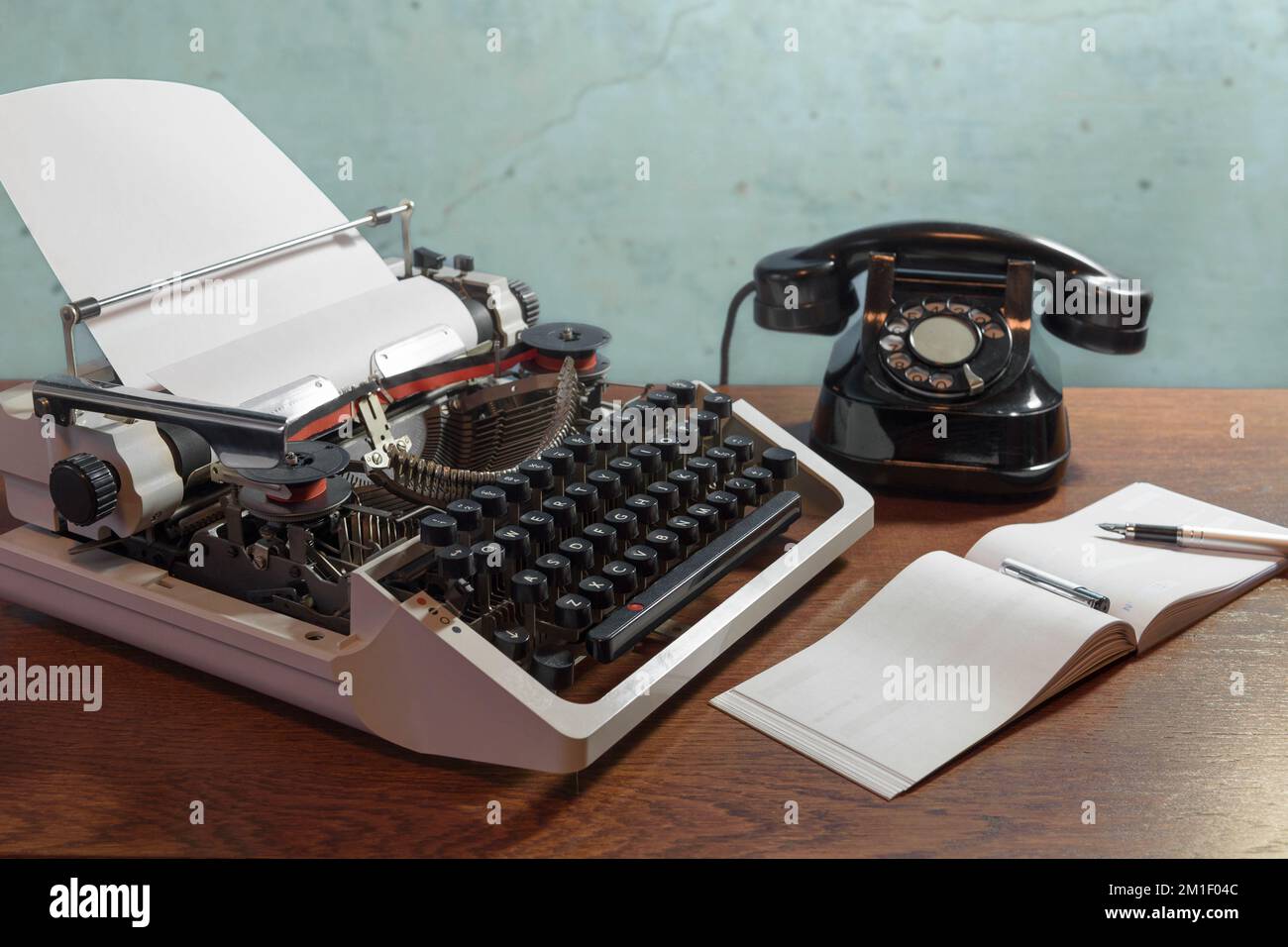 Chequera con página en blanco. Concepto retro con viejo teléfono, bolígrafo de tinta y máquina de escribir. Foto de stock