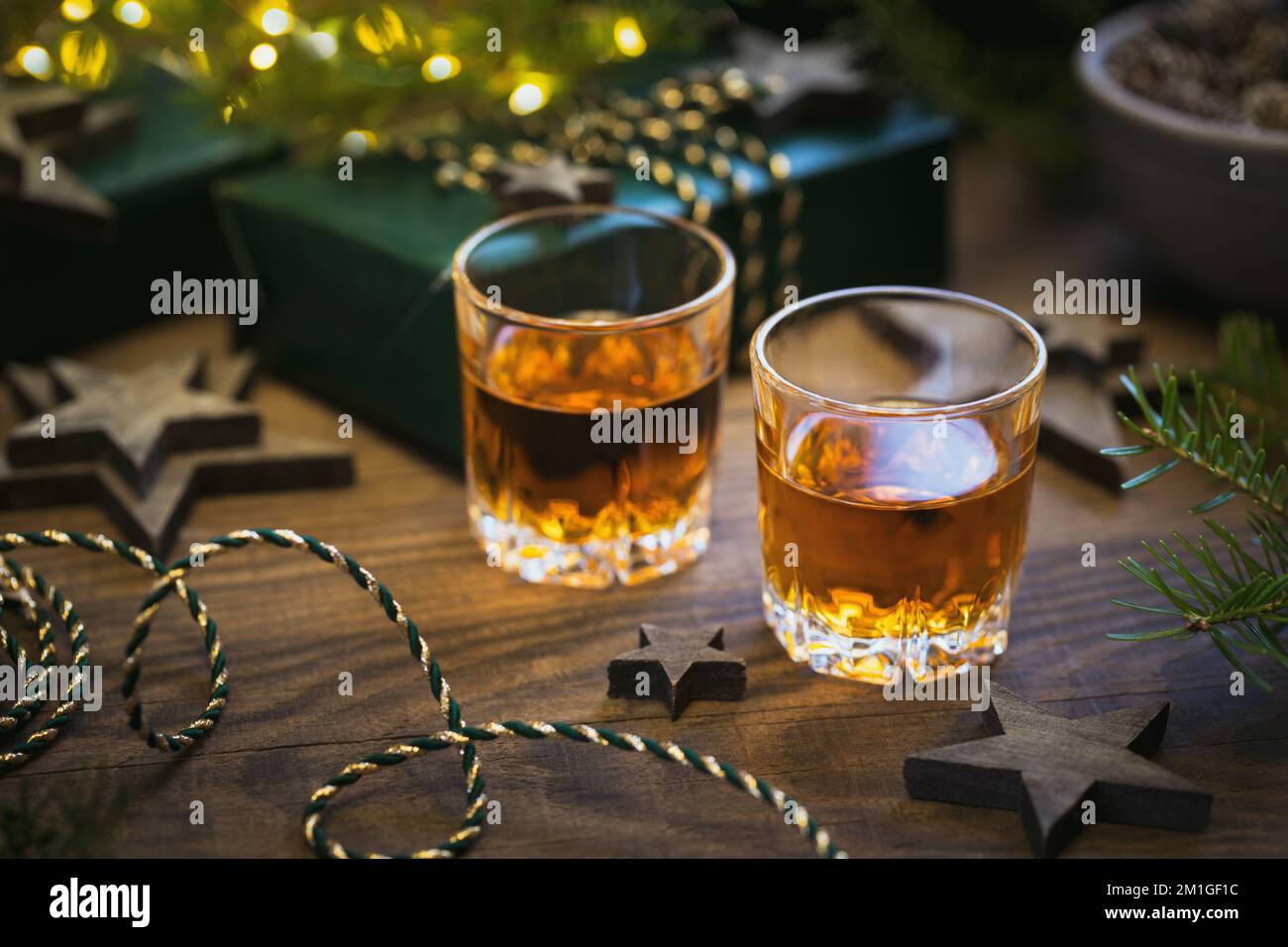 Dos copas de whisky o bourbon con decoración navideña Foto de stock