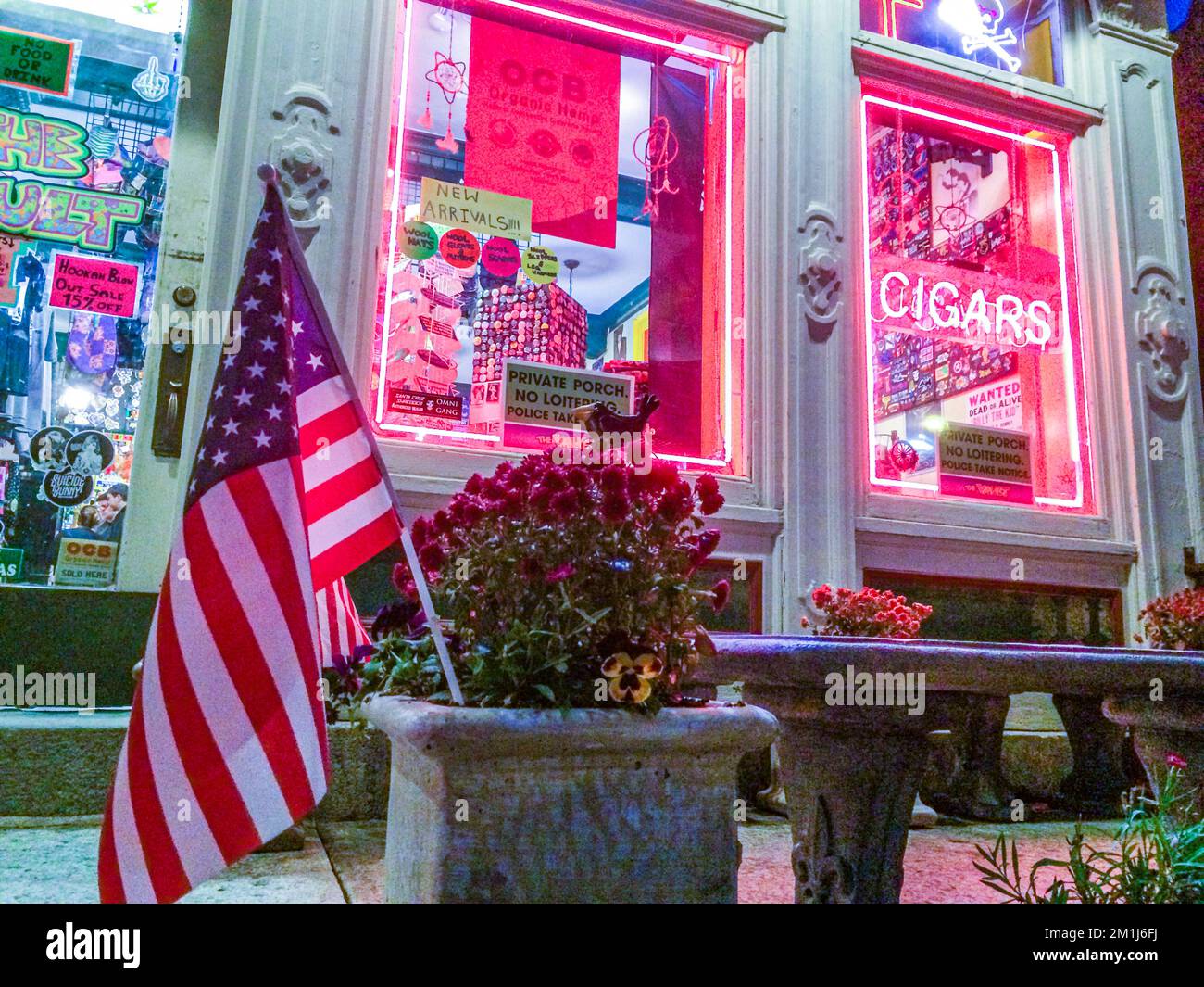 Una bandera americana delante de una tienda en el centro de Northampton, MA - tomada por la noche. Foto de stock