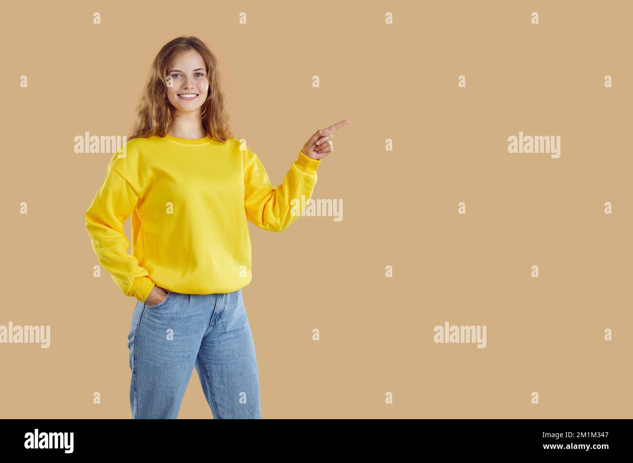 Sonriendo mujer joven casual en una sudadera amarilla se divierte