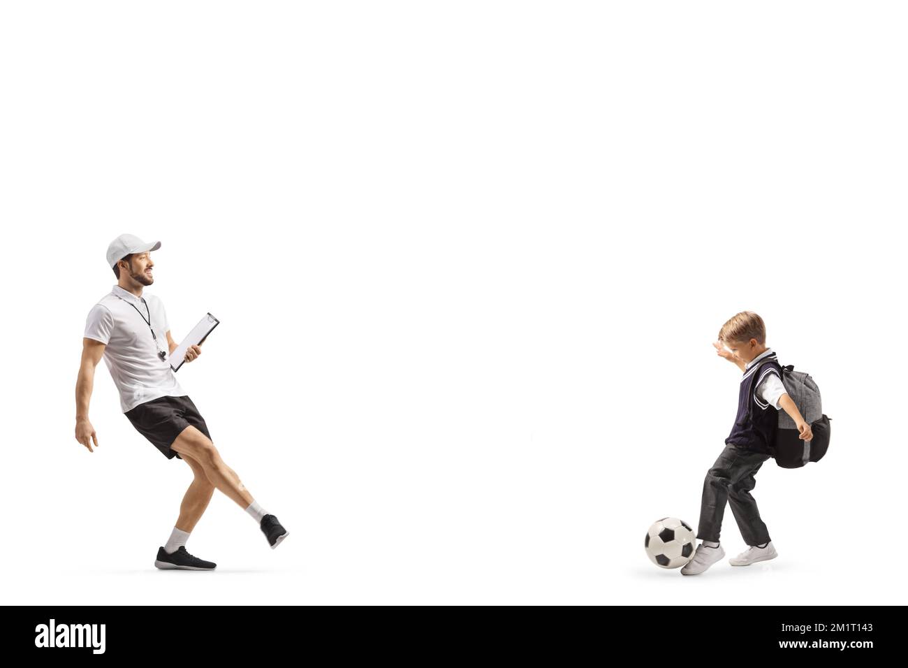 Entrenador de fútbol con un silbato sosteniendo un sujetapapeles y entrenando con un estudiante de escuela aislado sobre fondo blanco Foto de stock