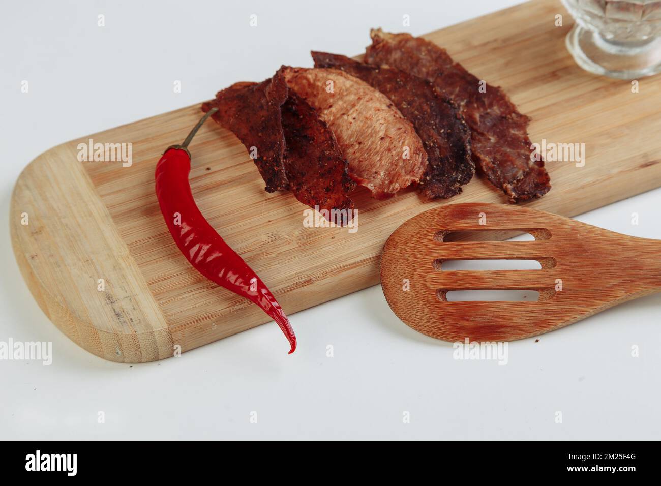 Algunas cajas de cartón artesanal con golosinas deshidratadas, la más alta se abre, llena de sabores crujientes de carne seca de ternera y pollo. Mascota casera Foto de stock