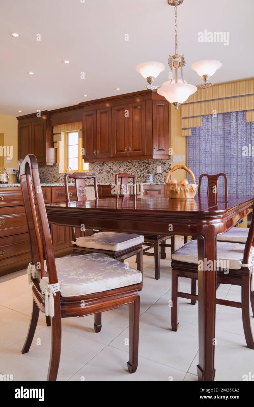 Vitrinas marrones y barnizadas y mesa de comedor con sillas de respaldo  alto en la cocina dentro de casa moderna, Quebec, Canadá. Esta imagen es  propiedad rel Fotografía de stock - Alamy