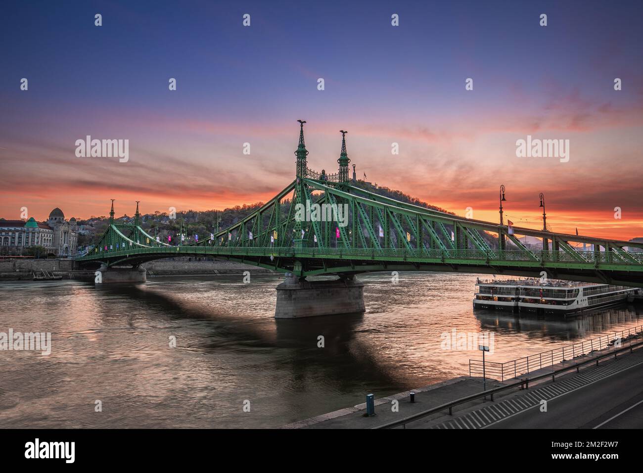 Budapest, Hungría - Vista panorámica del Puente de la Libertad al atardecer con la Colina Gellert y la Estatua de la Libertad al fondo Foto de stock