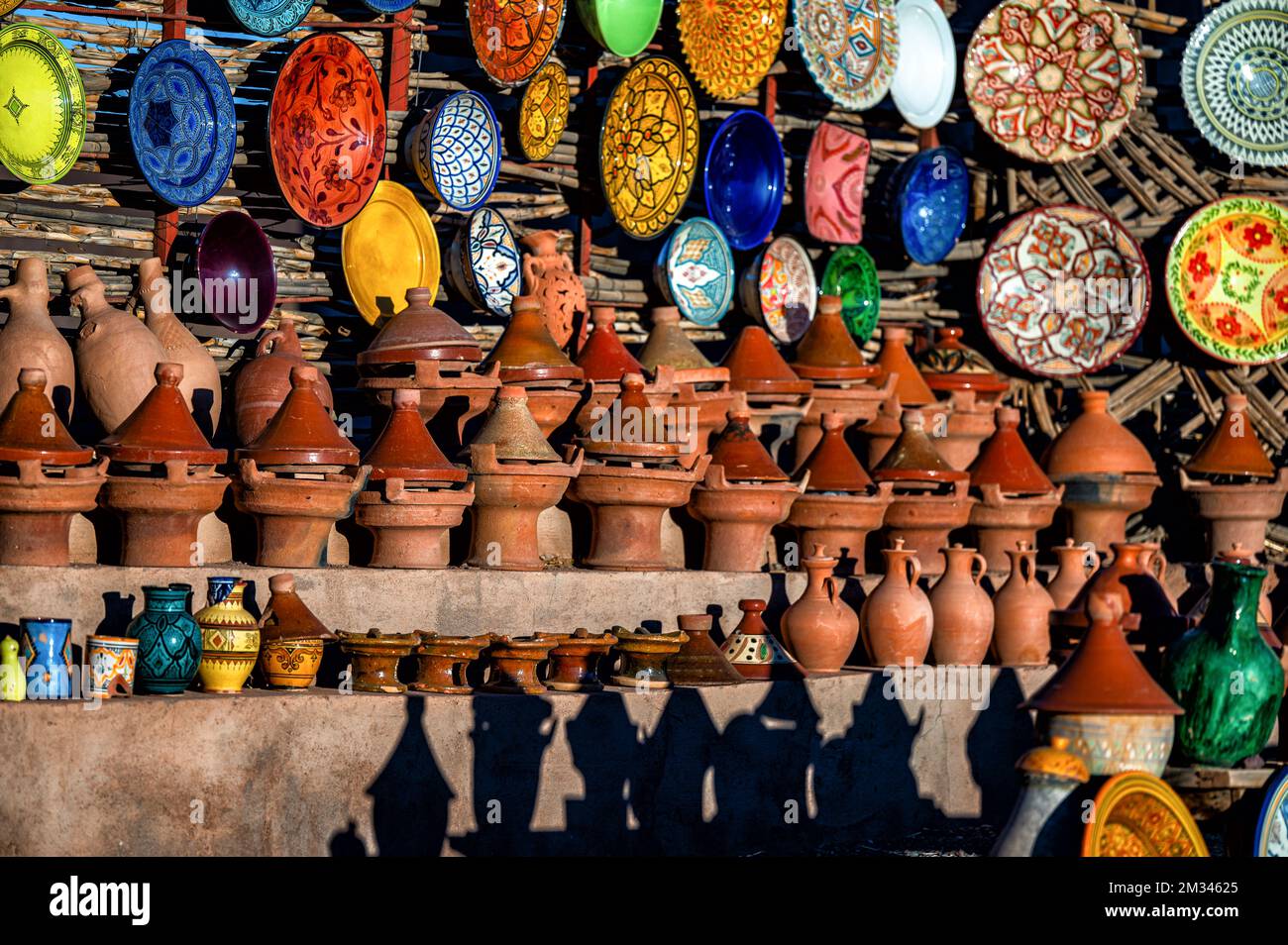 Tazentout, Ouarzazate, Marruecos - 28 de noviembre de 2022 - Un conjunto de platos tradicionales de arcilla marroquí hechos a mano en la tienda local. Cuencos, platos, tagines, ju Foto de stock