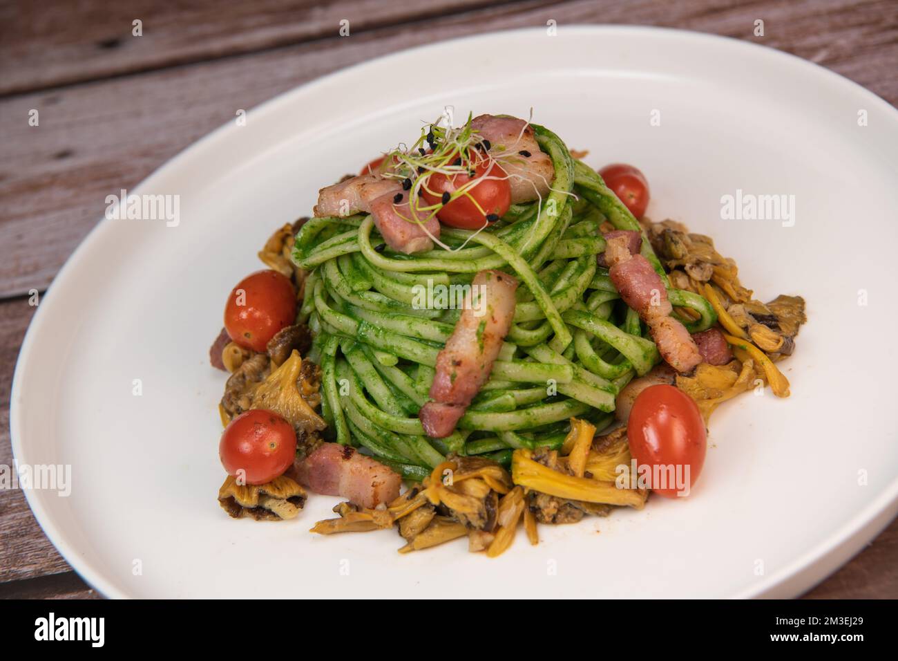 Receta de espaguetis con crema de espinacas y tocino ahumado, tomates y  champiñones rebozados Fotografía de stock - Alamy