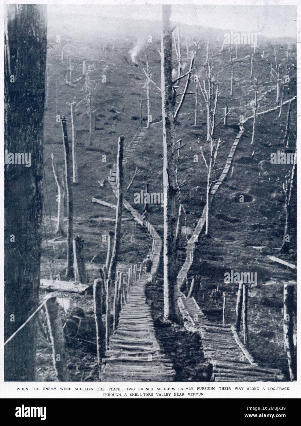 Dos soldados franceses se abren camino a lo largo de las pistas de troncos que cruzan el paisaje marcado dejado por los bombardeos alemanes cerca de Verdún. Foto de stock