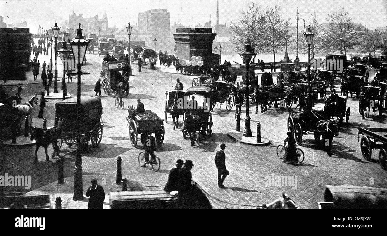 Cruce en el extremo norte del puente Old Blackfriars, Londo. Este puente fue reemplazado por un nuevo puente en 1909. Carros tirados por caballos y carruajes compiten con los ciclistas por el espacio en la carretera. Fecha: 1900s Foto de stock
