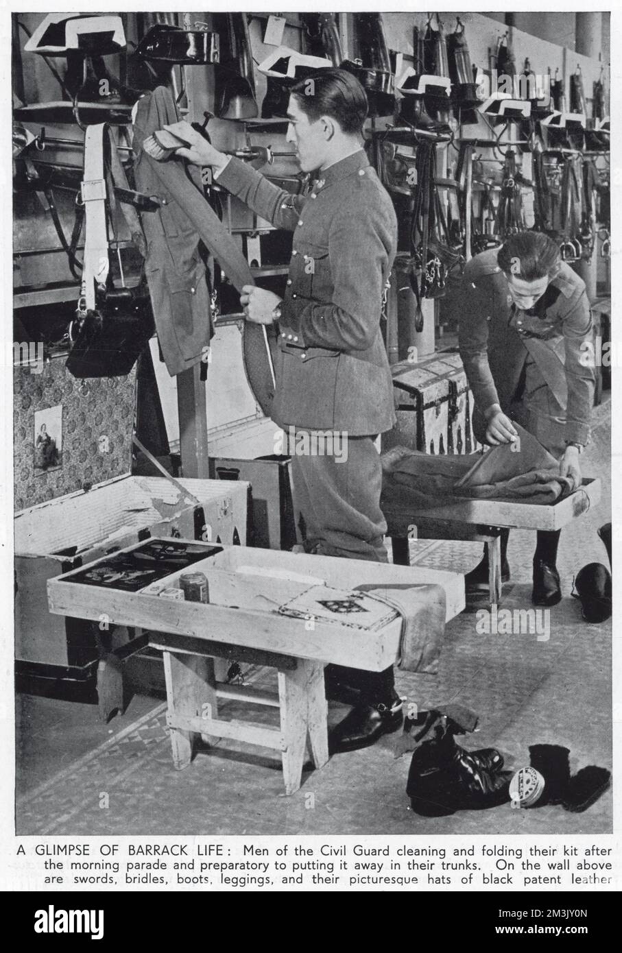 Fotografía que muestra a dos guardias civiles limpiando su kit en sus cuarteles, España, 1936. La Guardia Civil fue un cruce entre una unidad militar y una fuerza policial, que trabajó para mantener la paz y el orden en España tanto en tiempos de guerra como de paz. La Guardia Civil tomó un papel activo en la Guerra Civil Española, con guardias sirviendo tanto a los republicanos como a los nacionalistas. Foto de stock