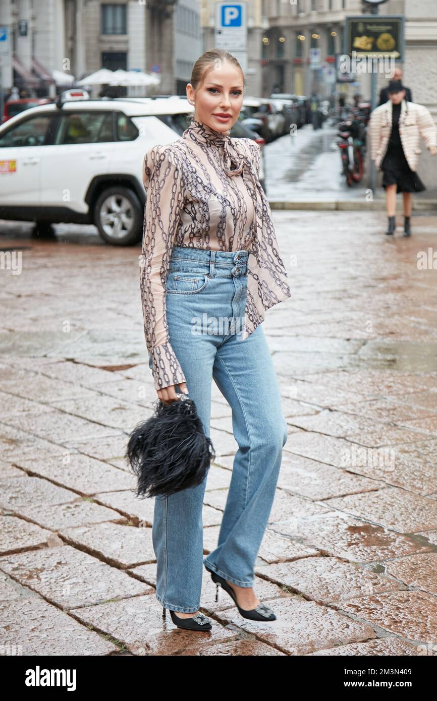 MILÁN, ITALIA - 24 DE SEPTIEMBRE de 2022: Mujer con pantalones vaqueros  azules y camisa de seda con cadenas diseñada antes de la filosofía del  desfile Lorenzo Serafini Fotografía de stock - Alamy