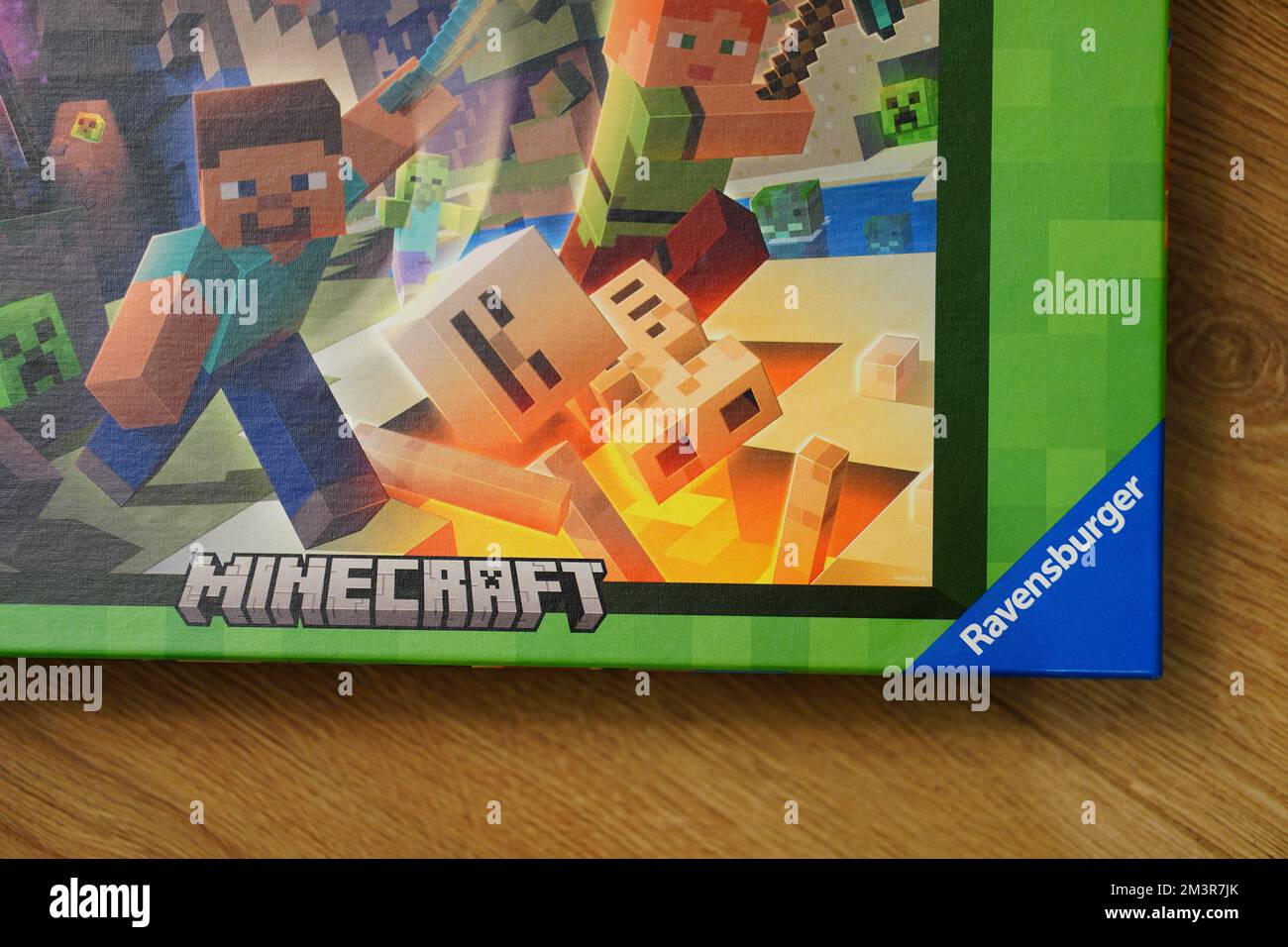 Un primer plano del rompecabezas Minecraft de la marca 'Ravensburger' en una sobre la superficie de madera Fotografía de stock -