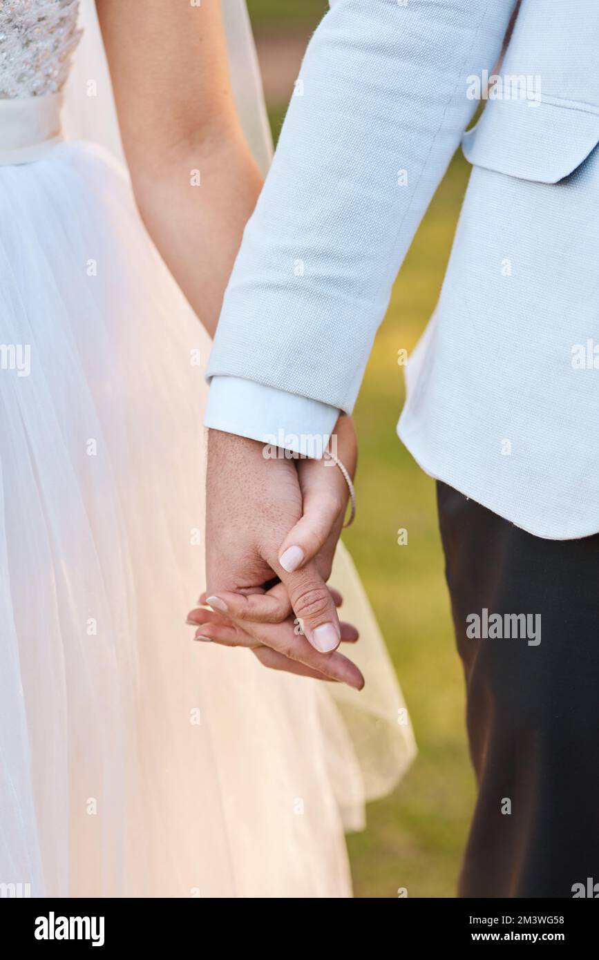 El matrimonio es un gesto simbólico de nuestro compromiso mutuo. una pareja irreconocible sujetando las manos el día de su boda. Foto de stock