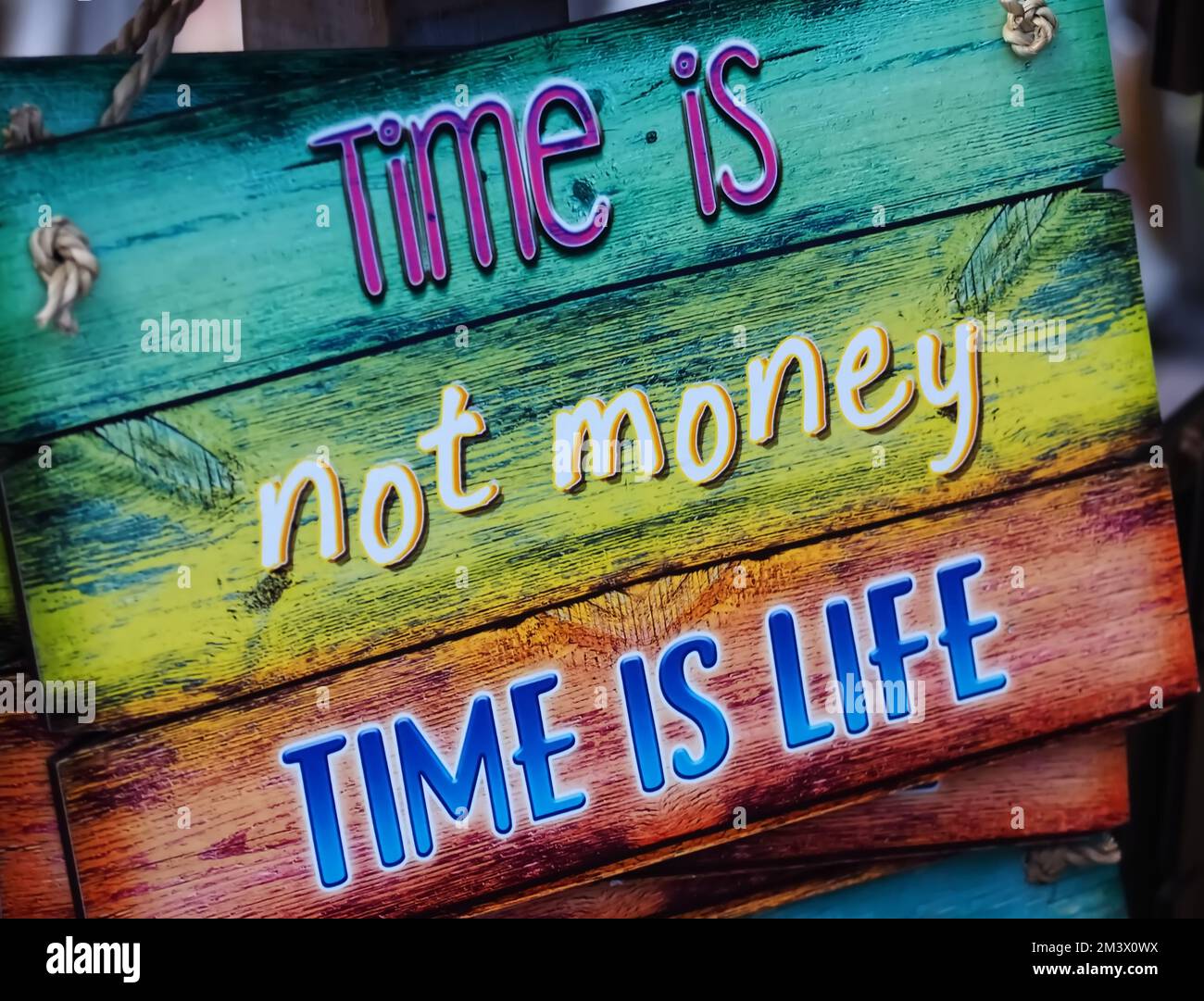 El tiempo colorido de la muestra de madera no es el dinero El tiempo es la vida Foto de stock