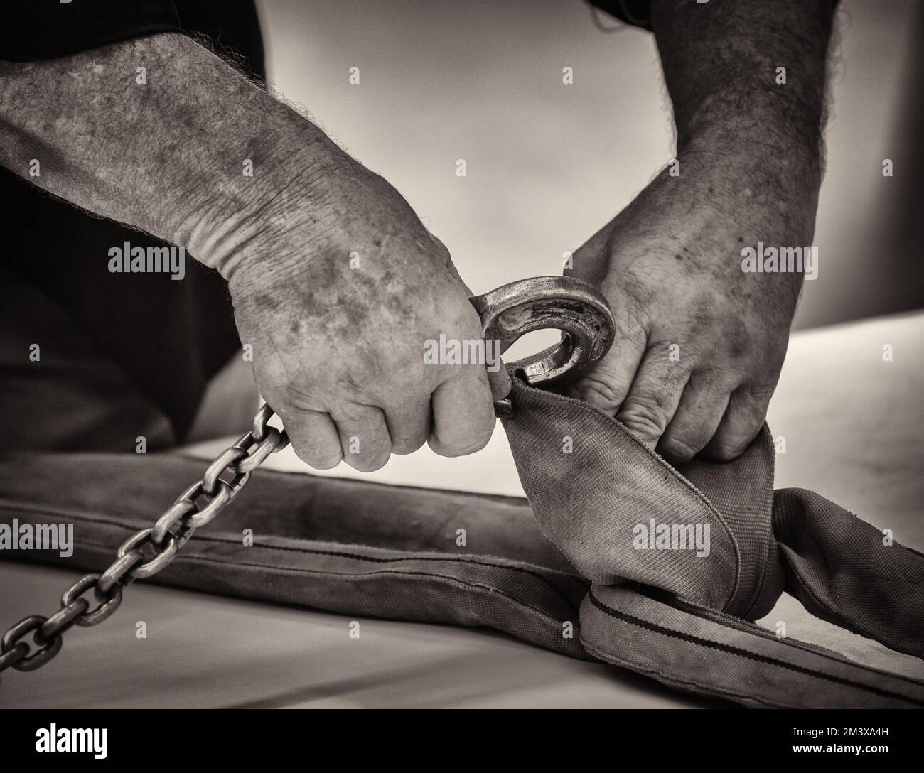 Sepia de manos de un hombre que conecta el gancho a una eslinga industrial  Fotografía de stock - Alamy