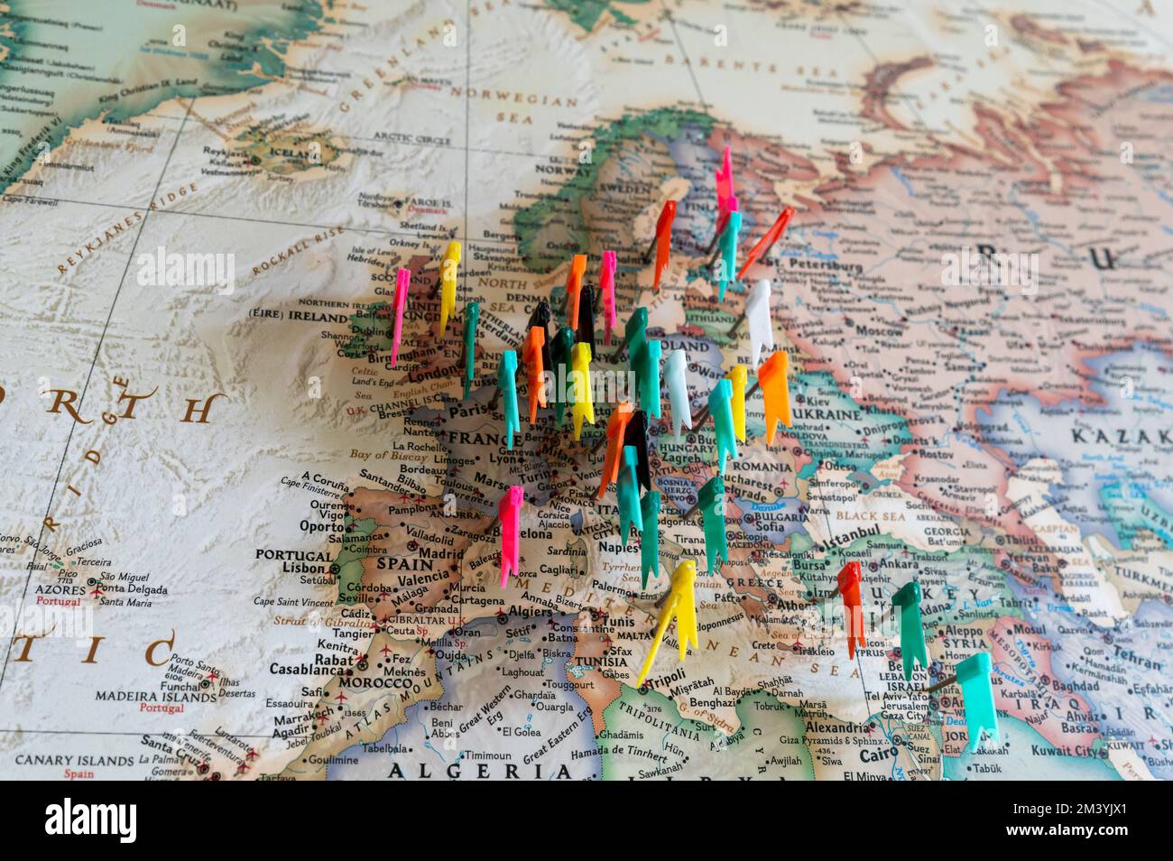Concepto de viaje con chinchetas de bandera y mapa del mundo.